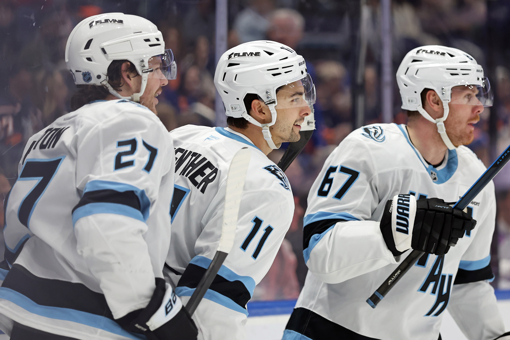 Utah Mammoth right wing Dylan Guenther (11) reacts after scoring his third goal of the game in the third period of an NHL hockey game against the New York Islanders, Thursday, Jan. 1, 2026, in Elmont, N.Y. (AP Photo/Adam Hunger)