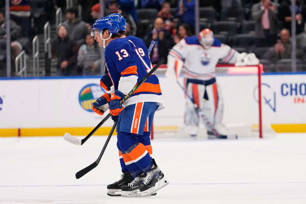 New York Islanders' Mathew Barzal (13) skates past Edmonton Oilers goaltender Stuart Skinner after scoring a goal during the first period of an NHL hockey game Thursday, Oct. 16, 2025, in Elmont, N.Y. (AP Photo/Frank Franklin II)