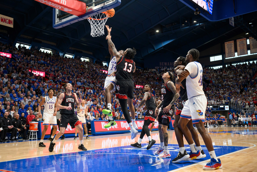 Kansas guard Melvin Council Jr. (14) goes up for a shot against Utah forward Kendyl Sanders (13) during the first half of an NCAA college basketball game in Lawrence, Kan., Saturday, Feb. 7, 2026. (AP Photo/Reed Hoffmann)