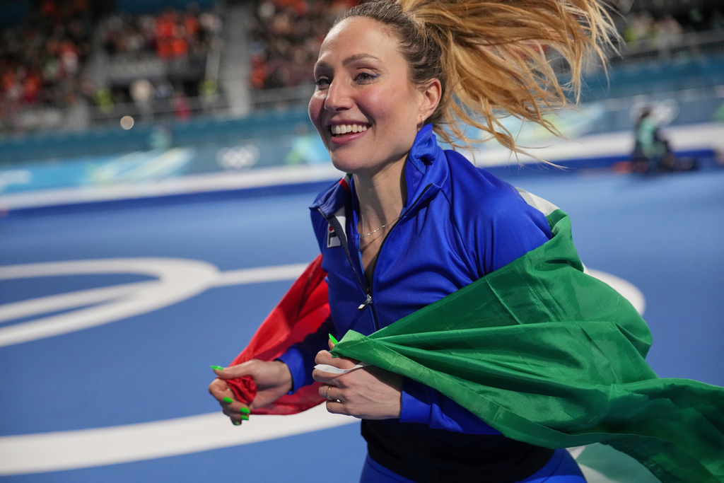 Gold medallist Francesca Lollobrigida of Italy celebrates with the Italian flag after the women's 3,000 meters speedskating race at the 2026 Winter Olympics, in Milan, Italy, Saturday, Feb. 7, 2026. (AP Photo/Christophe Ena)