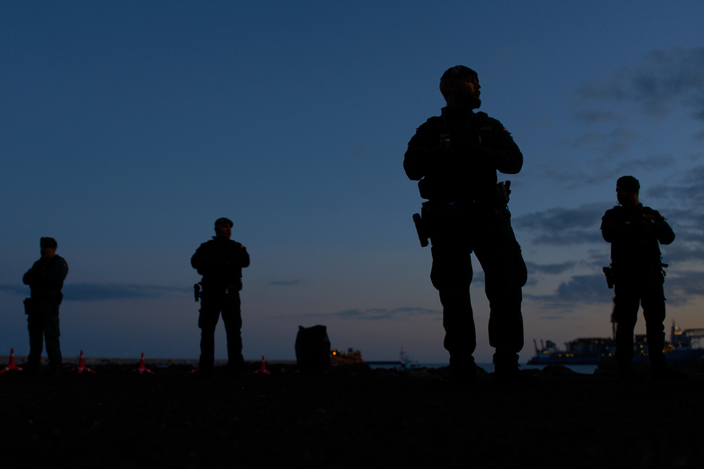 Spanish Civil Guard officers stand guard in the area where passengers from the MV Hondius cruise ship are expected to arrive at the port of Granadilla in Tenerife, Canary Islands, Spain, Saturday, May 9, 2026. (AP Photo/Manu Fernandez)