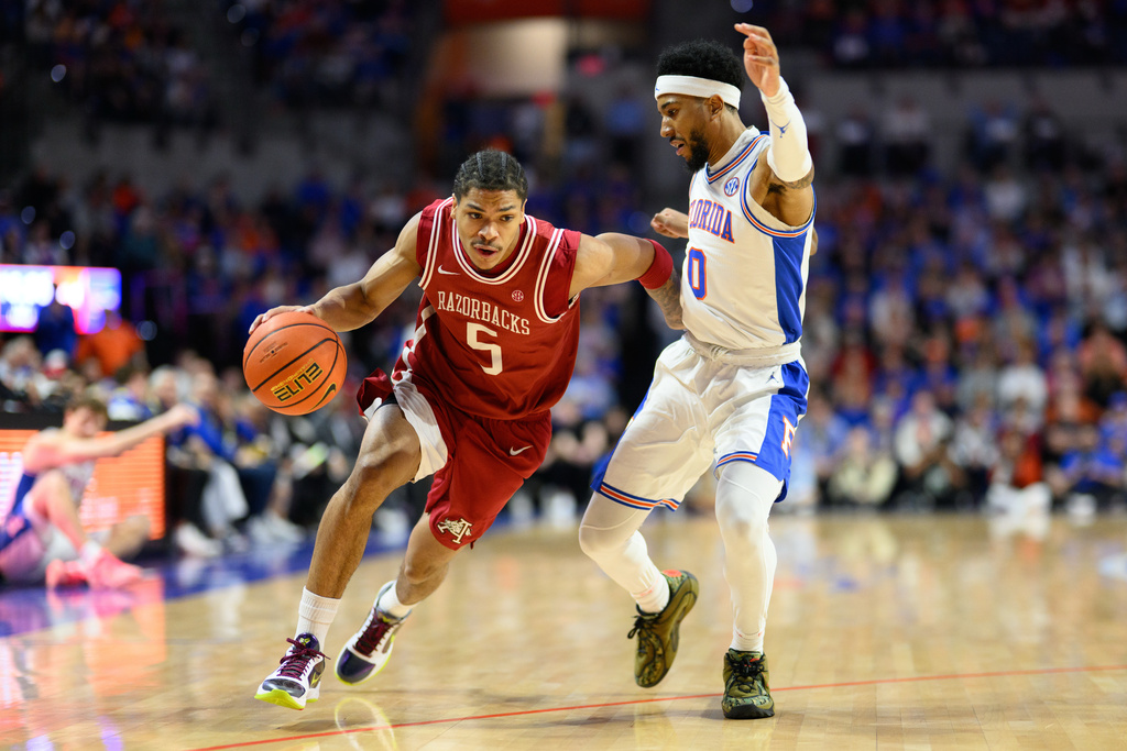 Arkansas guard Darius Acuff Jr. (5) drives against Florida guard Boogie Fland (0) during the first half of an NCAA college basketball game, Saturday, Feb. 28, 2026, in Gainesville, Fla. (AP Photo/Noah Lantor)