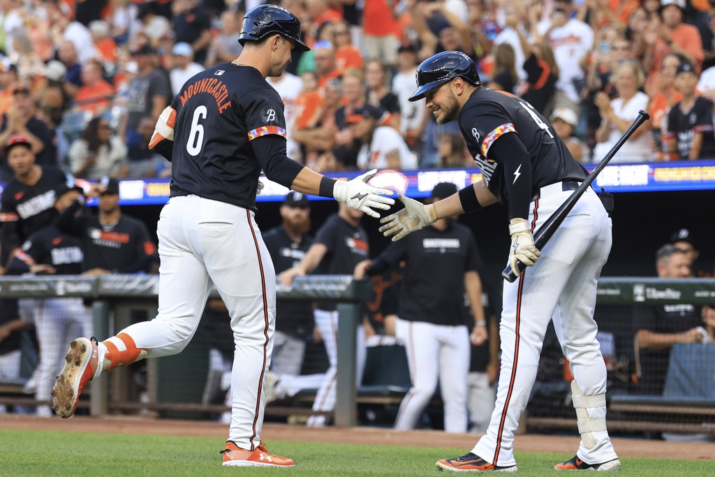 Baltimore Orioles' Ryan Mountcastle, left, high-fives Ryan Noda, right, after hitting a solo home run during the first inning of a baseball game against the Athletics, Friday, Aug. 8, 2025, in Baltimore. (AP Photo/Alyssa Howell)