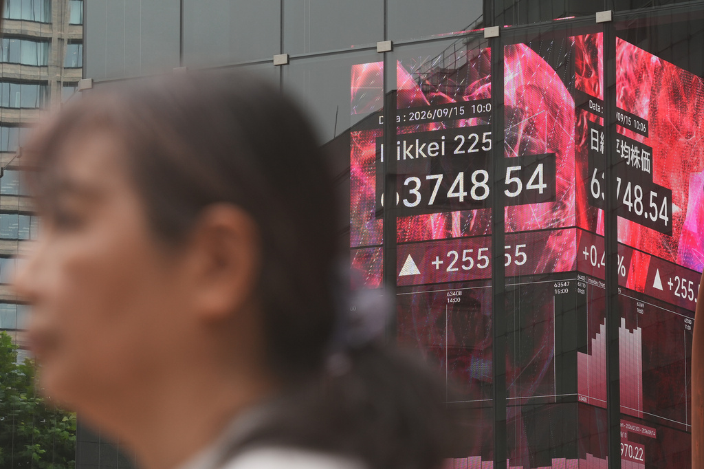 A person stands in front of an electronic stock board showing Japan's Nikkei index at a securities firm Tuesday, Sept. 15, 2026, in Tokyo. (AP Photo/Eugene Hoshiko)