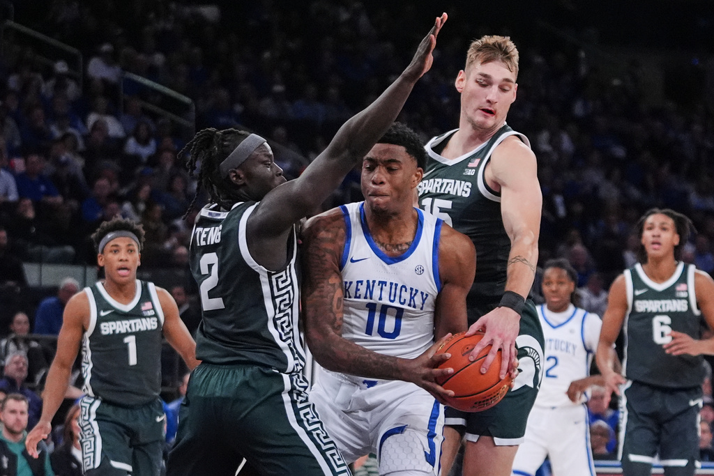 Michigan State's Kur Teng (2) and Carson Cooper defeend Kentucky's Brandon Garrison (10) during the first half of an NCAA college basketball game Tuesday, Nov. 18, 2025, in New York. (AP Photo/Frank Franklin II)