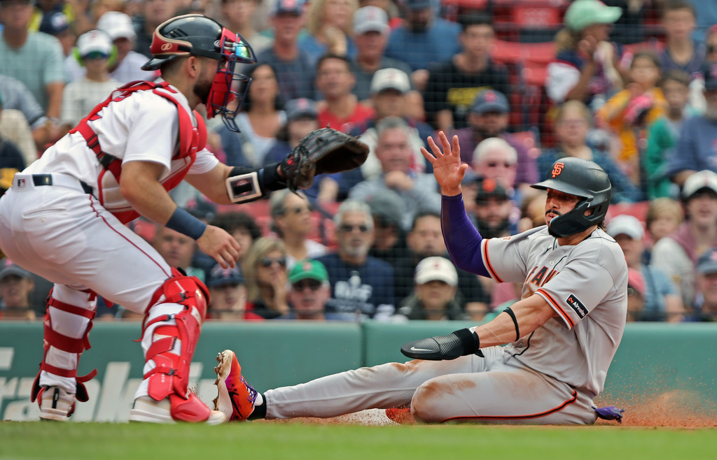 San Francisco Giants' Willy Adames, right, beats the throw to Boston Red Sox catcher Conner Wong, left, as he scores in the first inning of a baseball game Sunday, Aug. 23, 2026, in Boston. (AP Photo/Jim Davis)