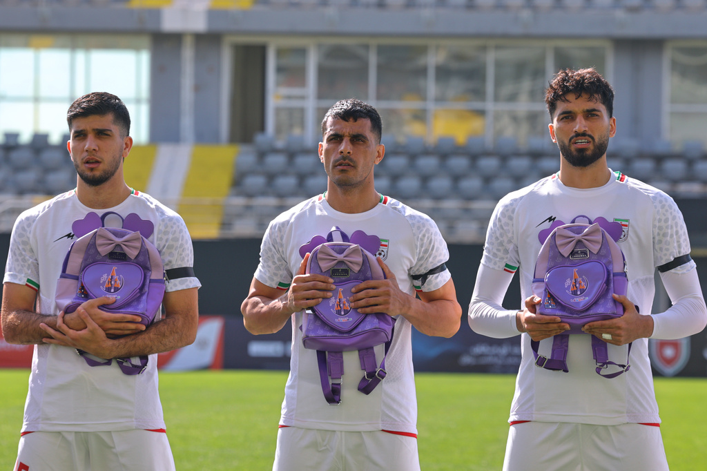 Iran's players sing national anthem holding school bags symbolizing children allegedly killed in a U.S. strike on a school in Minab before a friendly soccer match between Iran and Nigeria, in Antalya, southern Turkey, Friday, March 27, 2026. (AP Photo/Riza Ozel)
