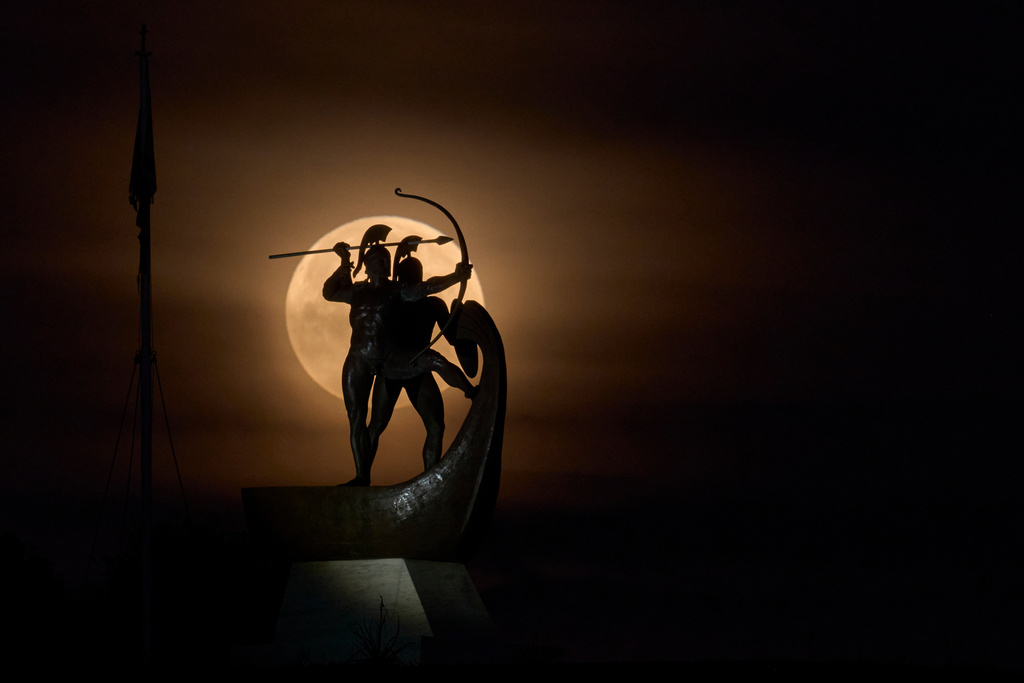 The Worm Moon sets behind the Monument of the Salamis Fighters, also known as Salaminomachoi, on Tuesday, March 3, 2026, on Salamina island, Greece, honoring the ancient Greeks who died in the naval Battle of Salamis in 480 B.C. (AP Photo/Petros Giannakouris)