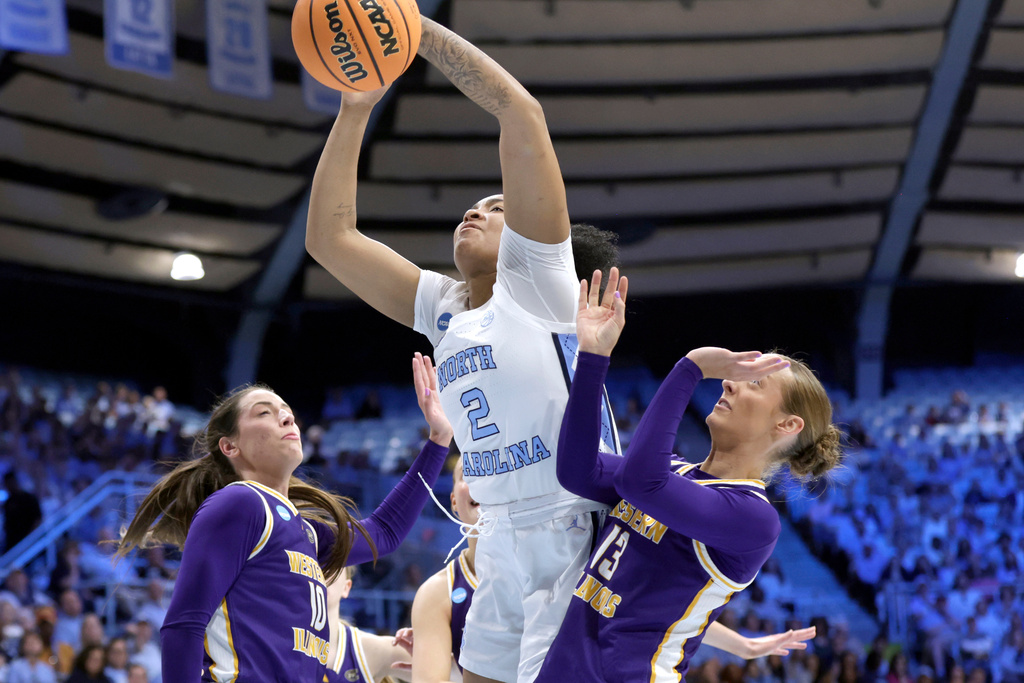 North Carolina forward Nyla Harris (2) drives against Western Illinois forward Mallory Shetley (10) and guard Addi Brownfield (13) during the first half in the first round of the NCAA college basketball tournament Friday, March 20, 2026, in Chapel Hill, N.C. (AP Photo/Chris Seward)