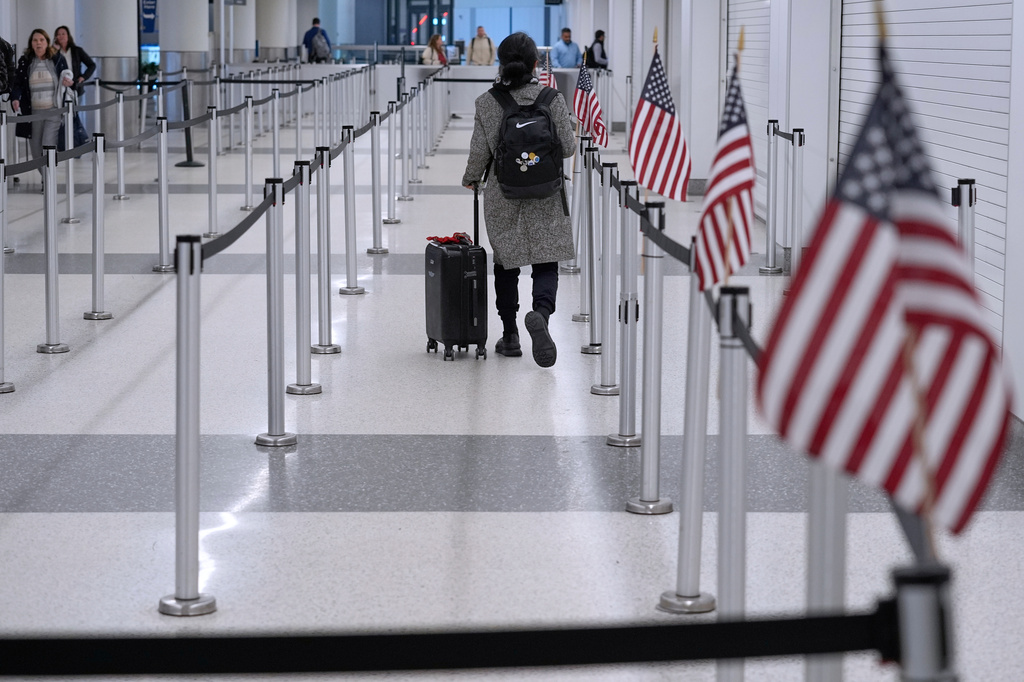 A traveler walks through a TSA security checkpoint in Terminal B, Friday, March 27, 2026, at Logan International Airport in Boston. (AP Photo/Robert F. Bukaty)