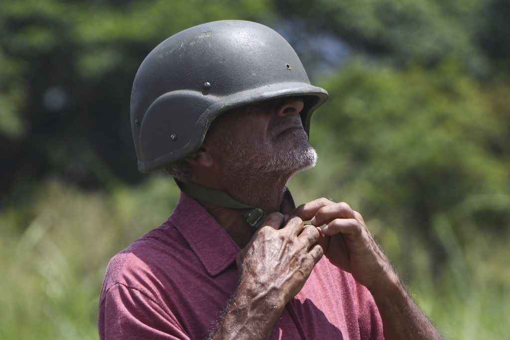 A member of the government-organized militias adjusts his helmet during military training at Fort Paramacay in Valencia, Venezuela, Saturday, Sept. 13, 2025. (AP Photo/Jacinto Oliveros)