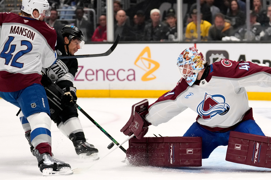 Los Angeles Kings left wing Trevor Moore, center, scores on goaltender Scott Wedgewood, right, as defenseman Josh Manson defends during the second period of Game 3 in the first round of the NHL hockey Stanley Cup playoffs Thursday, April 23, 2026, in Los Angeles. (AP Photo/Mark J. Terrill)
