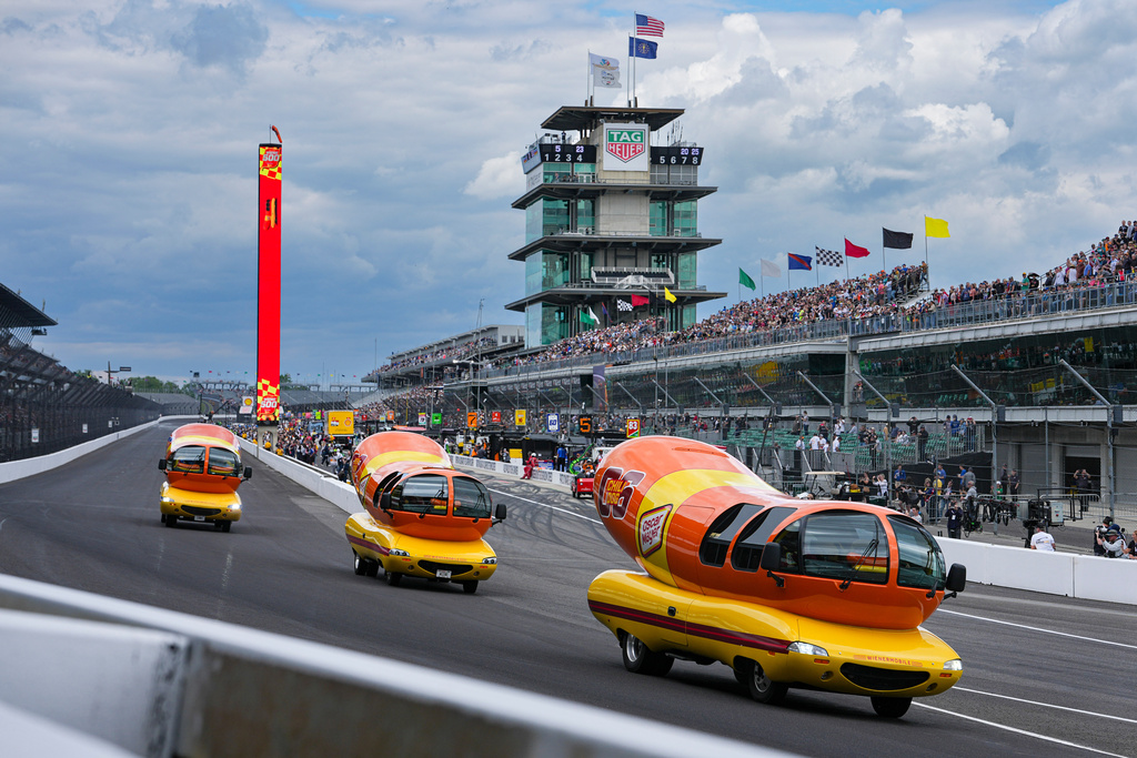 FILE - Oscar Mayer Wienermobiles head into the first turn as they compete in the Wienie 500 following the practice session for the Indianapolis 500 auto race at Indianapolis Motor Speedway in Indianapolis, May 23, 2025. (AP Photo/Michael Conroy, File)