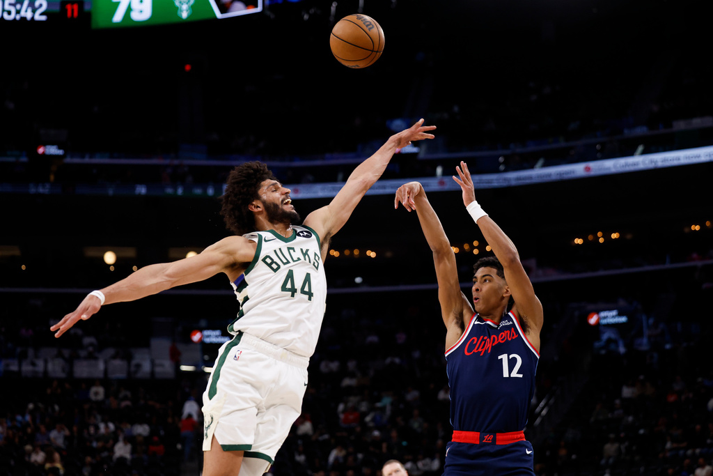LA Clippers guard Cam Christie (12) takes a shot while being guarded by Milwaukee Bucks guard Andre Jackson Jr. (44) during the second half of an NBA basketball game Monday, March 23, 2026, in Inglewood, Calif. (AP Photo/Caroline Brehman)