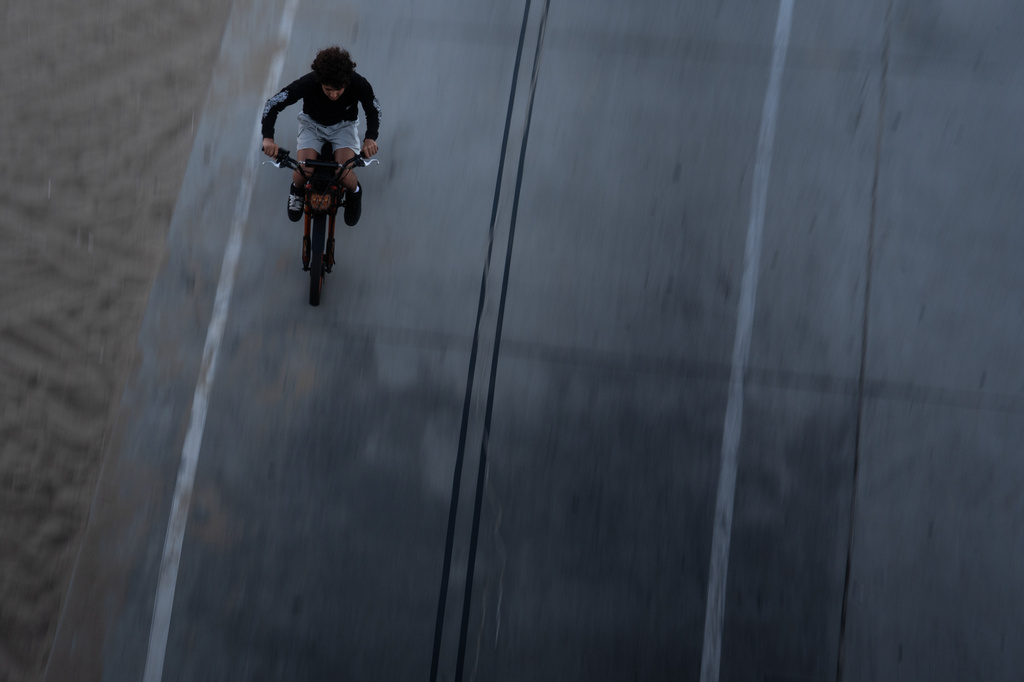 A boy rides an e-bike in Santa Monica, Calif., Monday, Aug. 10, 2026. (AP Photo/Jae C. Hong)