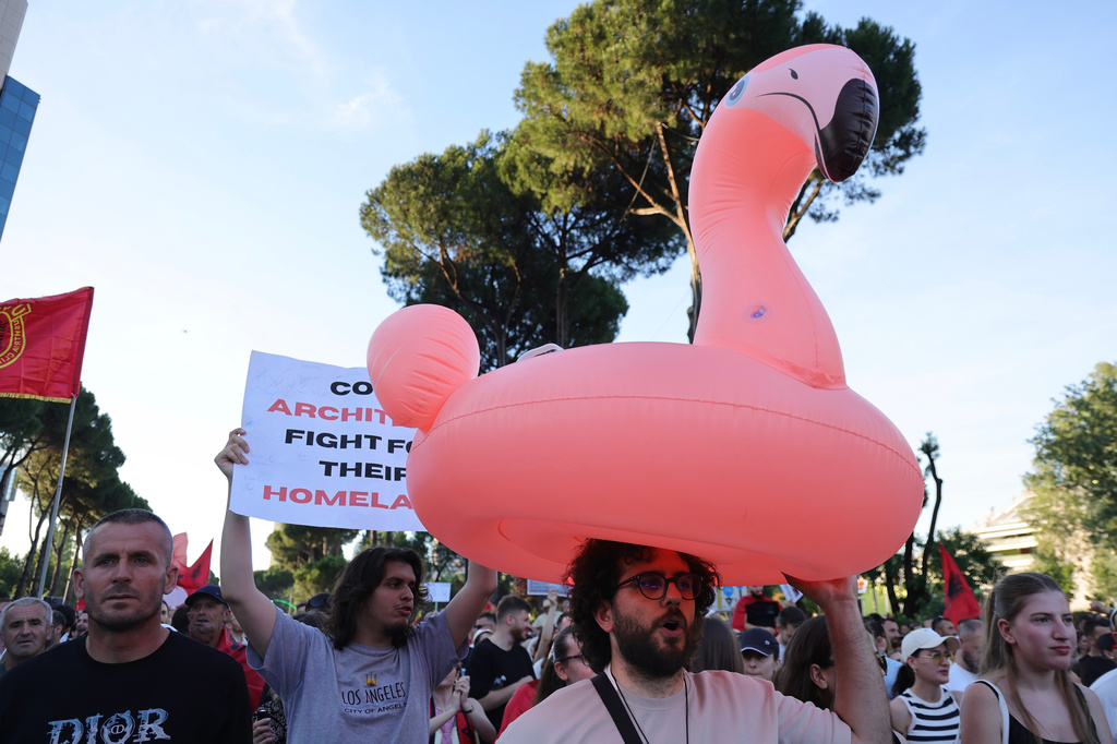 A protester carries a flamingo pool float during a rally in Tirana, Saturday, June 13, 2026, against the construction of a massive coastal development project linked to Jared Kushner and Ivanka Trump at Narta lagoon area, western Albania. (AP Photo/Hameraldi Agolli)