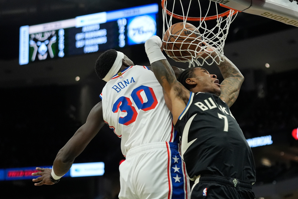 Milwaukee Bucks' Kevin Porter Jr. (7) dunks past Philadelphia 76ers' Adem Bona (30) during the first half of an NBA basketball game, Friday, Dec. 5, 2025, in Milwaukee. (AP Photo/Aaron Gash)