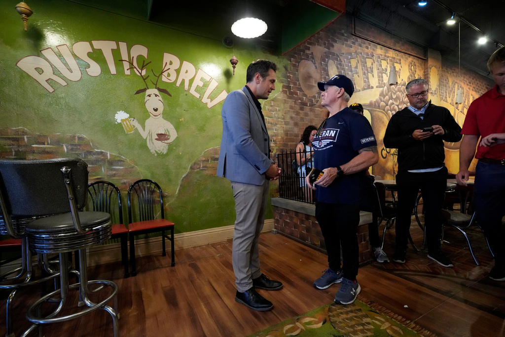 Zach Lahn, left, Republican candidate for Iowa governor, talks with Jim Warwick during a meet and greet, Tuesday, Aug. 4, 2026, in Hampton, Iowa. (AP Photo/Charlie Neibergall)