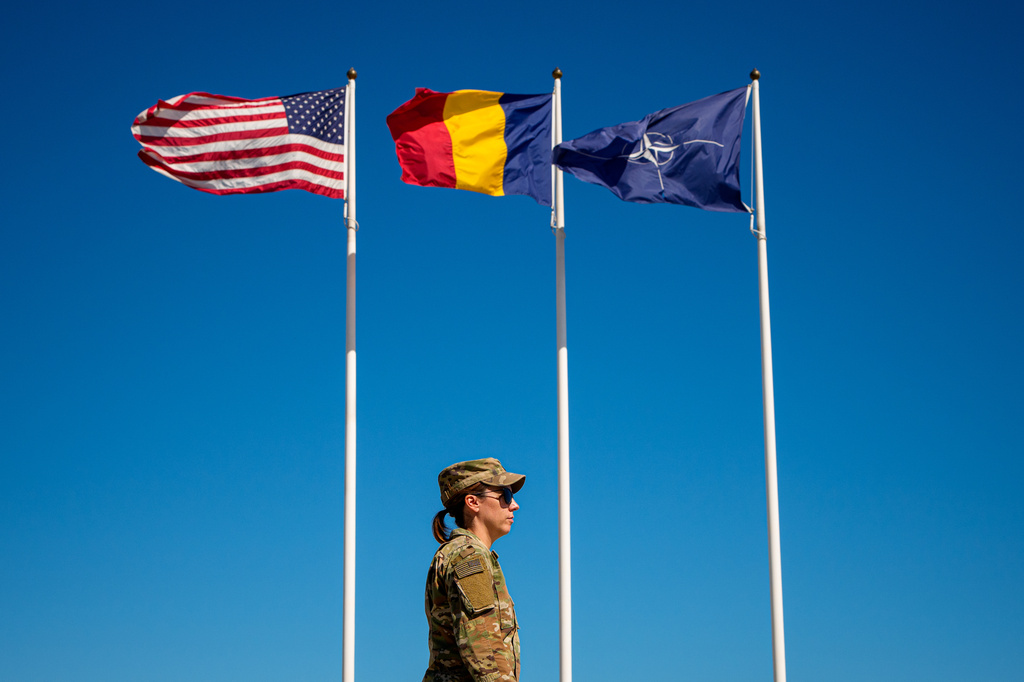 U.S. Staff Sergeant Alyssa Blom walks by flags at the Mihail Kogalniceanu Air Base, in Mihail Kogalniceanu, Romania, Thursday, Sept. 10, 2026. (AP Photo/Andreea Alexandru)