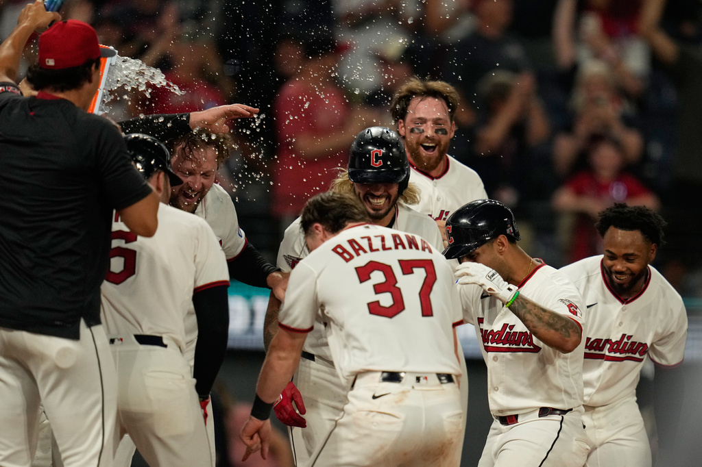 Cleveland Guardians' Brayan Rocchio, second from right, is mobbed by teammates as he runs to home plate after hitting a game winning home rum in the ninth inning of a baseball game against the Chicago White Sox in Cleveland, Thursday, July 2, 2026. (AP Photo/Sue Ogrocki)