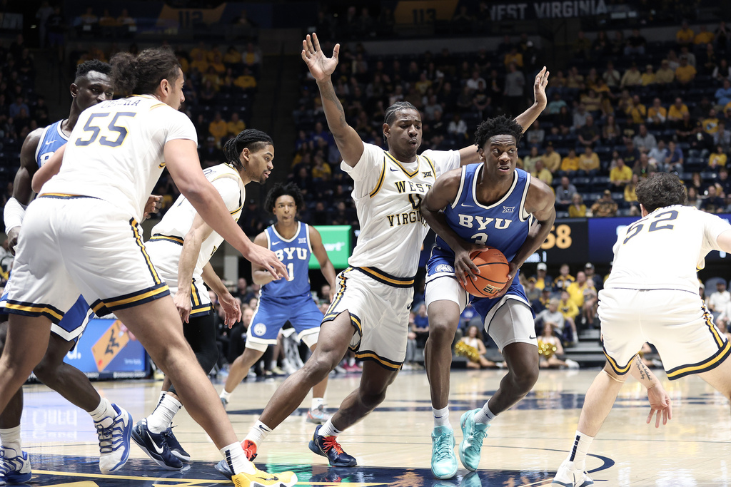 BYU forward AJ Dybantsa (3) is defended by West Virginia forward Brenen Lorient (0) during the first half of an NCAA college basketball game Saturday, Feb. 28, 2026, in Morgantown, W.Va. (AP Photo/Kathleen Batten)