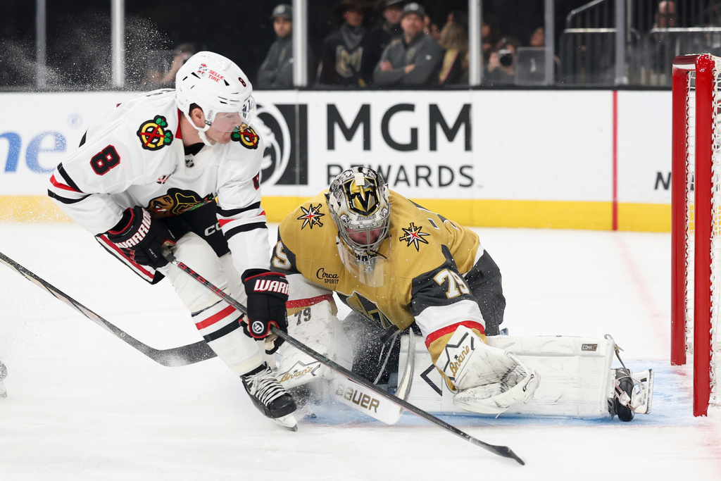 Vegas Golden Knights goaltender Carter Hart (79) stops a shot from Chicago Blackhawks center Ryan Donato (8) during the first period of an NHL hockey game Tuesday, Dec. 2, 2025, in Las Vegas. (AP Photo/Ian Maule)