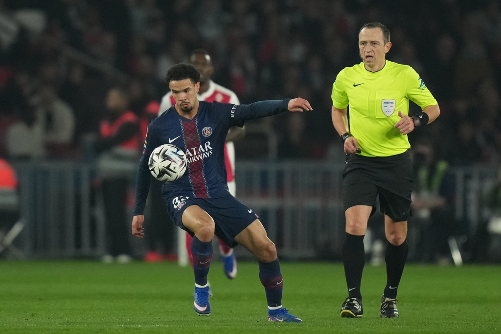 PSG's Warren Zaire-Emery, left, controls the ball past referee Ruddy Buquet during the French League One soccer match between Paris Saint-Germain and Monaco in Paris, Friday, March 6, 2026. (AP Photo/Thibault Camus)