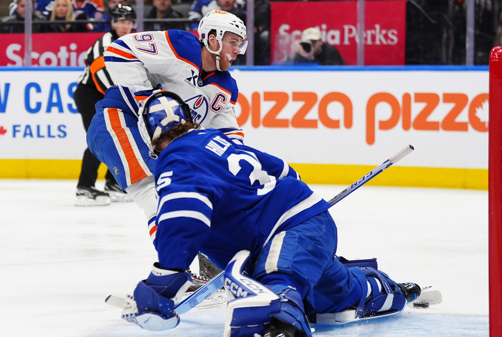 Edmonton Oilers' Connor McDavid (97) scores on Toronto Maple Leafs goaltender Dennis Hildeby during the first period of an NHL hockey game in Toronto, Saturday, Dec. 13, 2025. (Frank Gunn/The Canadian Press via AP)