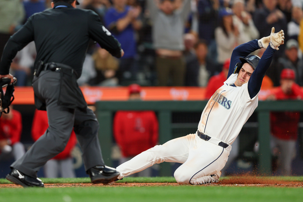 Seattle Mariners' Cole Young slides home on a single hit by Victor Robles in the seventh inning of a baseball game against the Los Angeles Angels, Tuesday, June 30, 2026, in Seattle. (AP Photo/Kevin Ng)