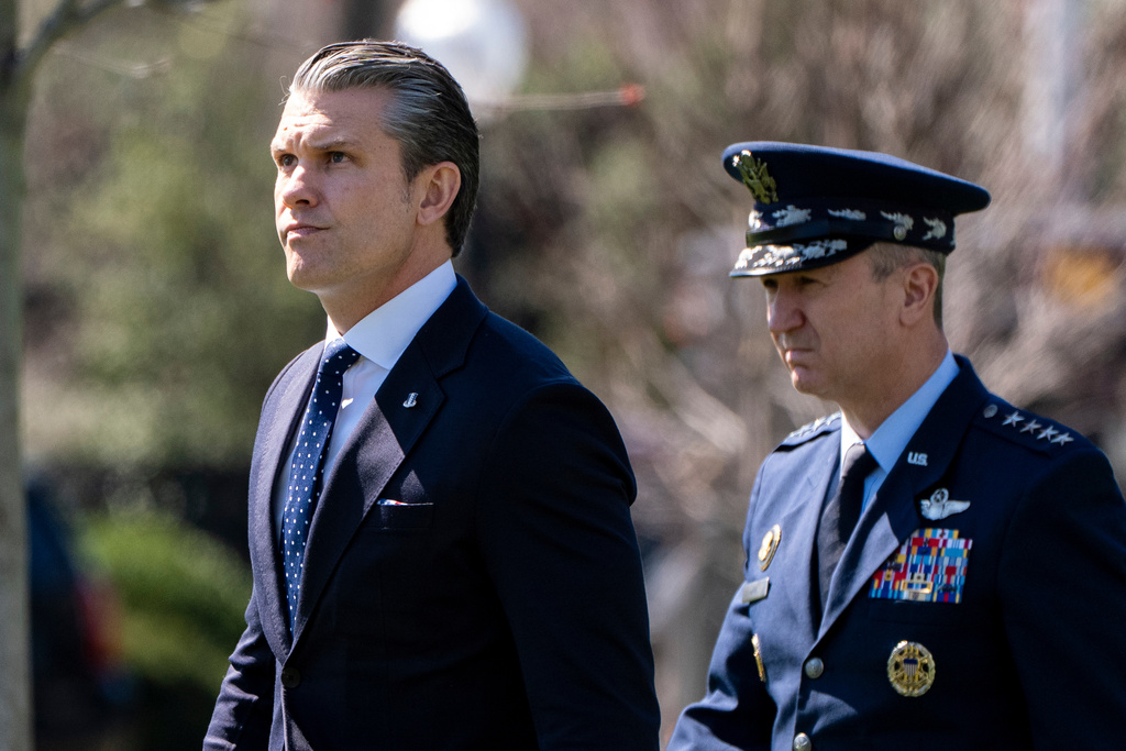 Defense Secretary Pete Hegseth, left, and Chairman of the Joint Chiefs of Staff Gen. Dan Caine walk to depart on Marine One with President Donald Trump from the South Lawn of the White House, Wednesday, March 18, 2026, in Washington. (AP Photo/Alex Brandon)