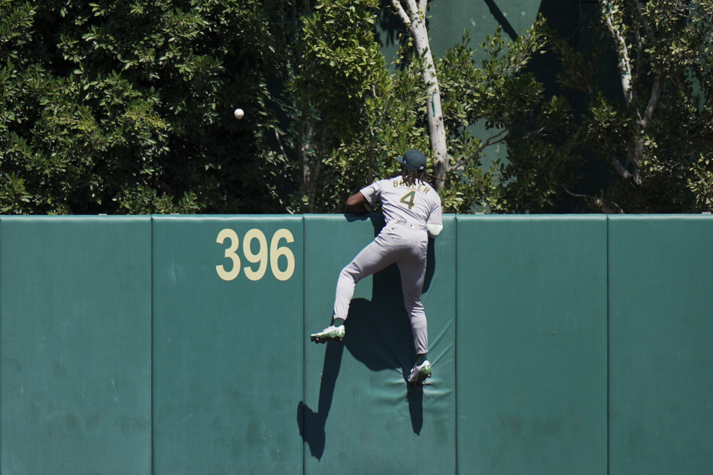 Athletics outfielder Lawrence Butler (4) watches as a two-run home run by Los Angeles Angels' Jo Adell clears the wall during the first inning of a baseball game, Sunday, Sept. 7, 2025, in Anaheim, Calif. (AP Photo/Jae C. Hong)