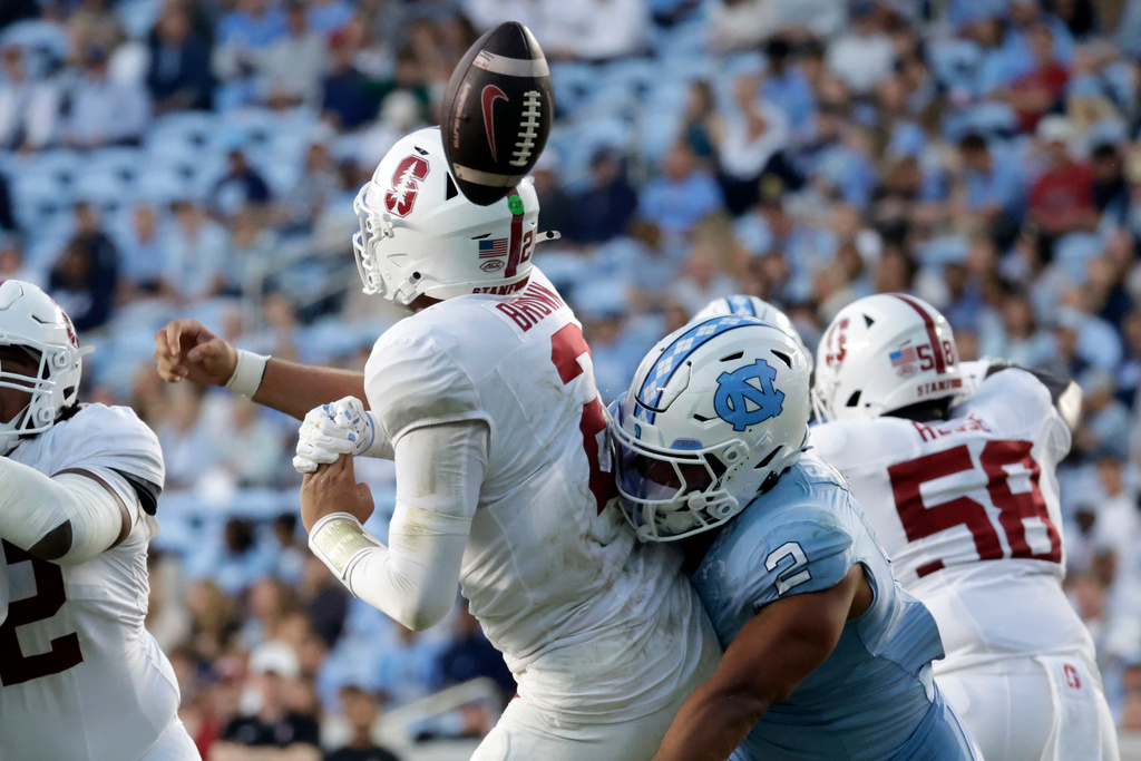 Stanford quarterback Elijah Brown (2) fumbles as he is hit by North Carolina linebacker Andrew Simpson, right, during the first half of an NCAA college football game Saturday, Nov. 8, 2025, in Chapel Hill, N.C. (AP Photo/Chris Seward)