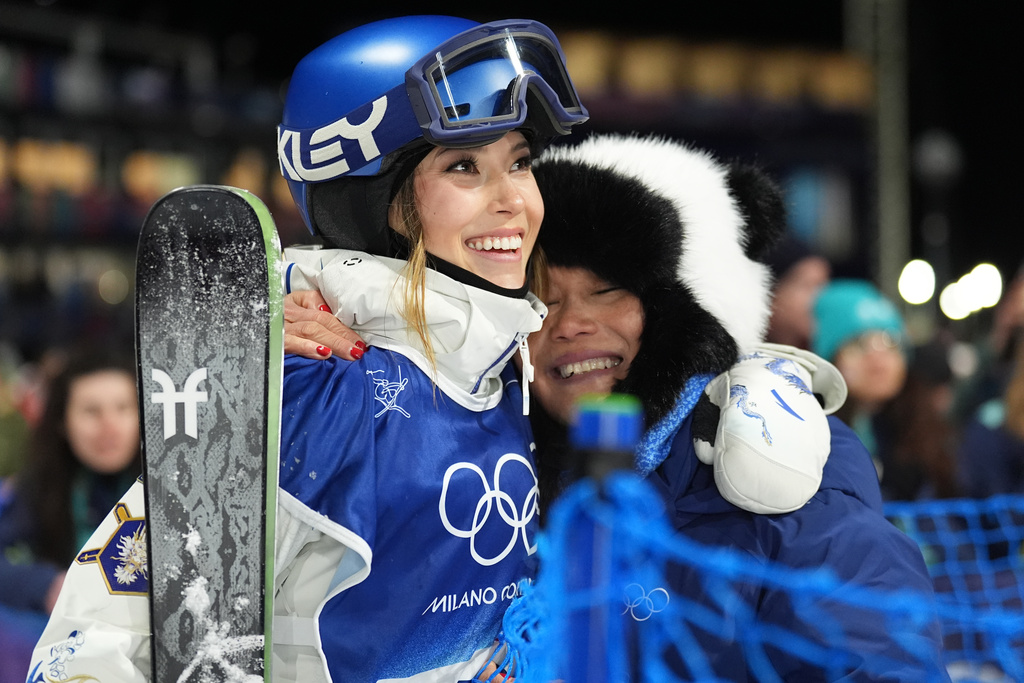 China's Eileen Gu, left, gets a hug from her mother Yan Gu as she competes in the women's freestyle skiing big air qualifications at the 2026 Winter Olympics, in Livigno, Italy, Saturday, Feb. 14, 2026. (AP Photo/Abbie Parr)