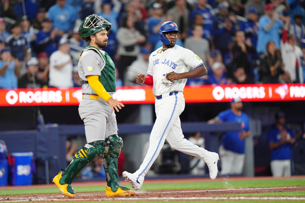 Toronto Blue Jays' Jesús Sánchez (12) scores a run in the seventh inning of a baseball game against the Athletics in Toronto, Saturday, March 28, 2026. (Frank Gunn/The Canadian Press via AP)