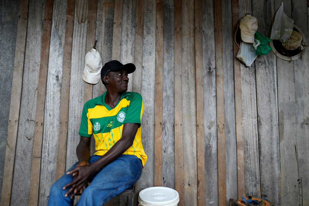 Reginaldo Nunes Fonseca sits on a balcony of the house he occupies in an area known as Nova Conquista or "new conquest" in Oiapoque, Amapa state, Brazil, Wednesday, March 11, 2026. (AP Photo/Eraldo Peres)