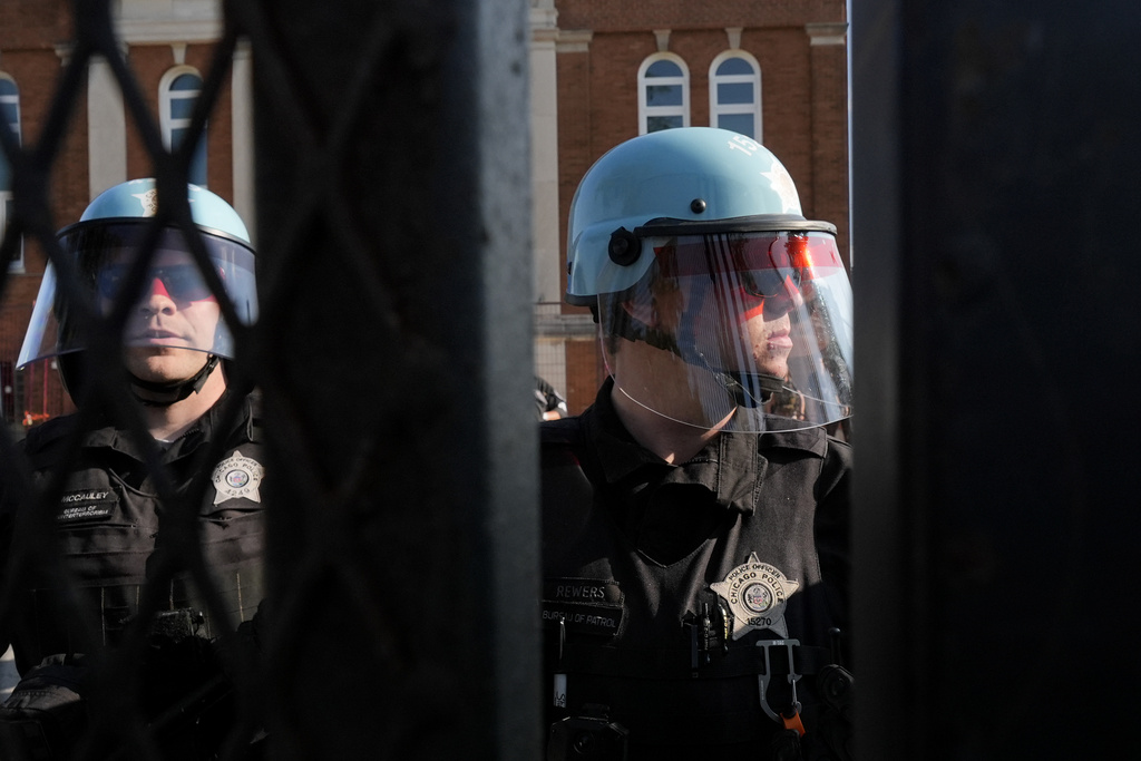 Police stand near where protesters knocked down a fence surrounding United Center at the Democratic National Convention after a march Monday, Aug. 19, 2024, in Chicago. (AP Photo/Frank Franklin II)