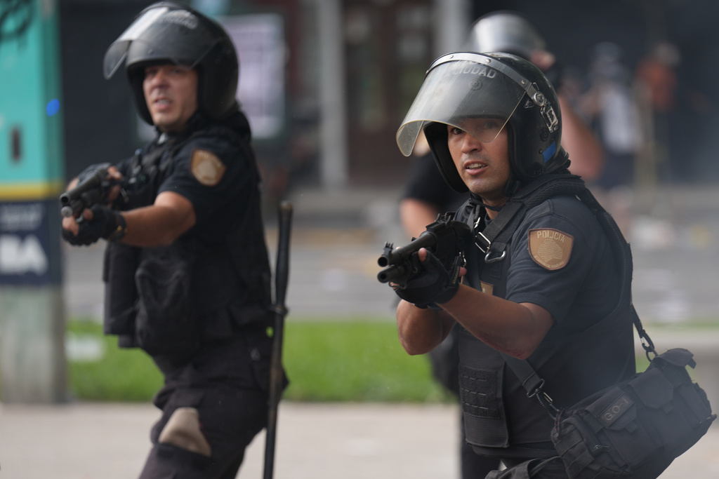 Police clash with protesters during a march by trade unions and opposition groups against a labor reform bill proposed by President Javier Milei's government in Buenos Aires, Argentina, Wednesday, Feb. 11, 2026. (AP Photo/Gustavo Garello)