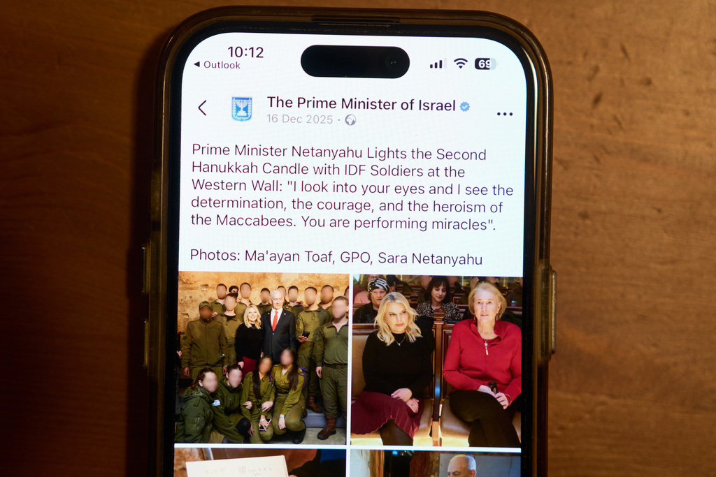 A Facebook post of the Prime Minister of Israel with a retouched photo of the Prime Minister’s wife, Sara Netanyahu, is displayed on a phone in Ramat Gan, Israel, Jan, 9, 2026 (AP Photo/Oded Balilty)