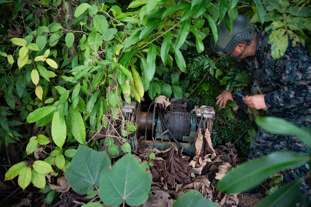 Peruvian Navy soldier discover a motor used for illegal mining near the Malinowski River in the Tambopata National Reserve in Puerto Maldonado, Peru, Tuesday, Aug. 11, 2026. (AP Photo/Guadalupe Pardo)