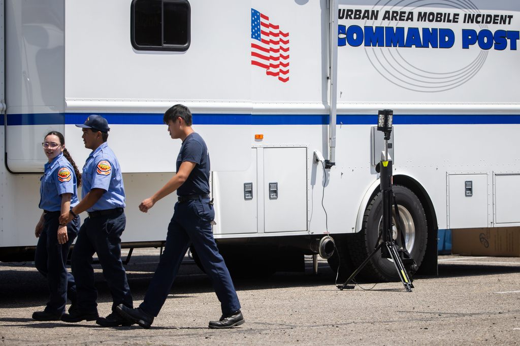 Emergency personnel work at the incident command post at the Los Alamitos Race Course in Cypress, Calif., on Sunday, May 24, 2026. (AP Photo/Ethan Swope)