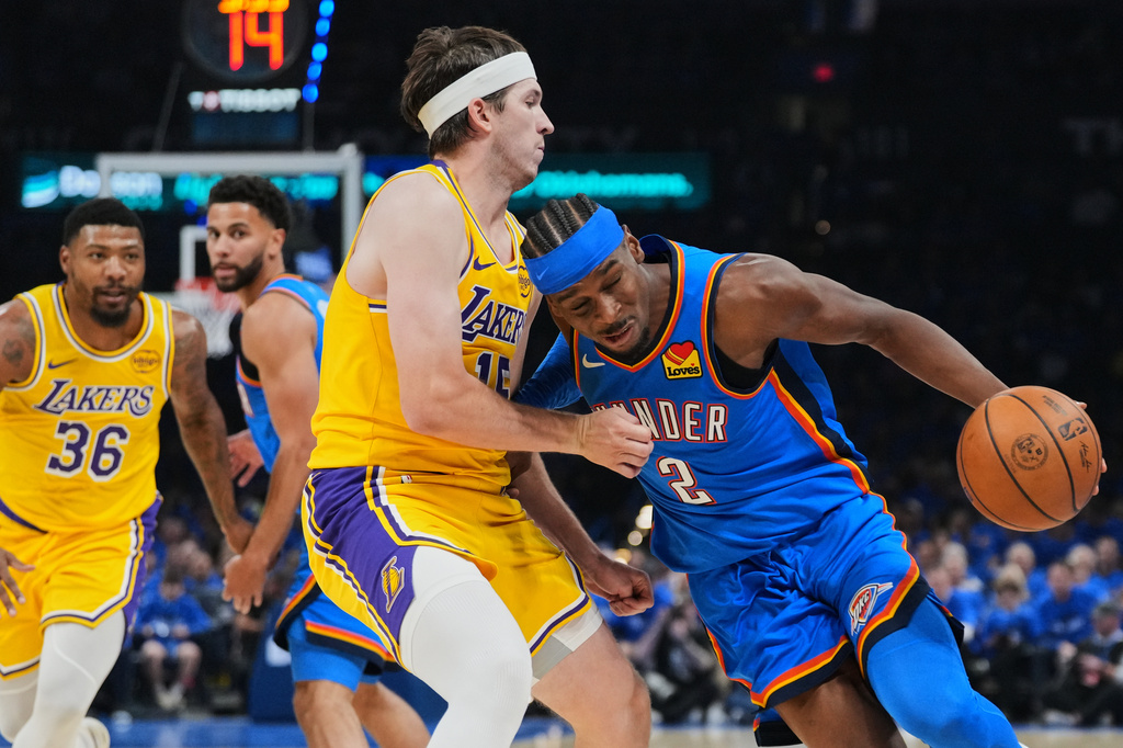 Oklahoma City Thunder guard Shai Gilgeous-Alexander (2) drives to the basket as Los Angeles Lakers' Austin Reaves, left, defends in the second half of Game 1 in a second-round NBA basketball playoffs series Tuesday, May 5, 2026 in Oklahoma City. (AP Photo/Kyle Phillips)