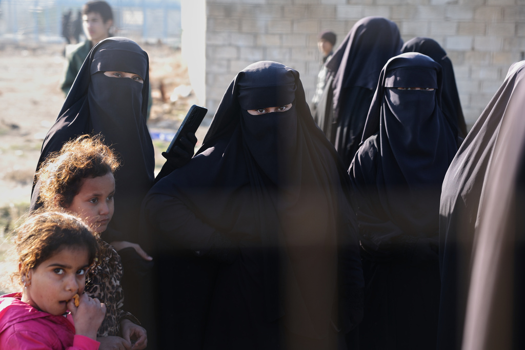 People stand inside the al-Hol camp in northeastern Syria's Hasakeh province, Syria, Wednesday, Jan. 21, 2026, after the withdrawal of the Syrian Democratic Forces (SDF). (AP Photo/Ghaith Alsayed)