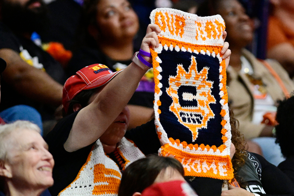 Connecticut Sun fan Adrianna Wilkinson, center left, of Brockton, Mass., holds up a handmade sign in the first half of a WNBA basketball game against the Toronto Tempo, Thursday, Sept. 24, 2026, in Uncasville, Conn. (AP Photo/Jessica Hill)