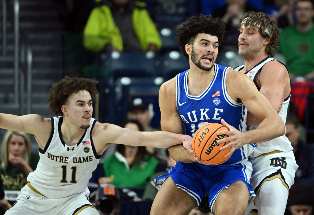 Notre Dame guard Braeden Shrewsberry (11) gets a hand on Duke forward Cameron Boozer during the first half of an NCAA basketball game, Tuesday, Feb. 24, 2026, in South Bend, Ind. (AP Photo/Marc Lebryk)