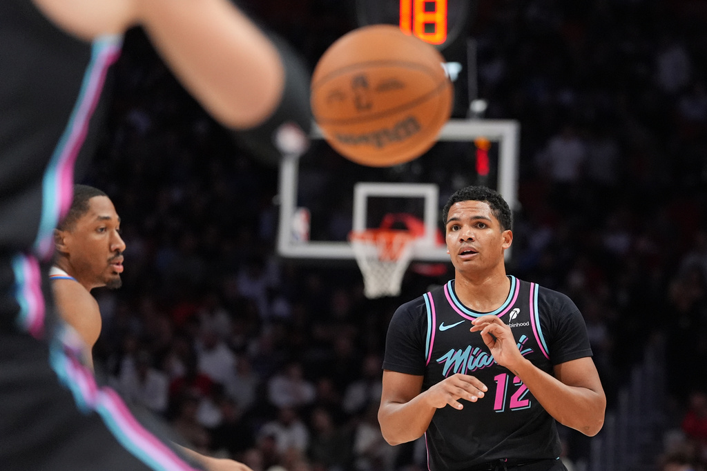 Miami Heat guard Dru Smith (12) passes the ball during the first half of an NBA basketball game against the Oklahoma City Thunder, Saturday, Jan. 17, 2026, in Miami. (AP Photo/Rebecca Blackwell)