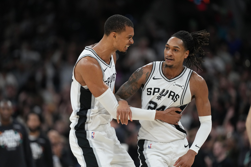San Antonio Spurs forward Victor Wembanyama, left, and guard Devin Vassell react after a basket against the Oklahoma City Thunder during the second half of Game 4 in the Western Conference finals NBA basketball playoffs series in San Antonio, Sunday, May 24, 2026. (AP Photo/Eric Gay)
