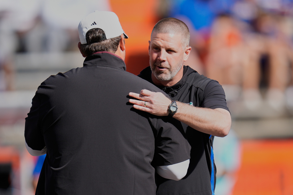 Mississippi State head coach Jeff Lebby, left, and Florida head coach Billy Napier greet each other before an NCAA college football game, Saturday, Oct. 18, 2025, in Gainesville, Fla. (AP Photo/John Raoux)