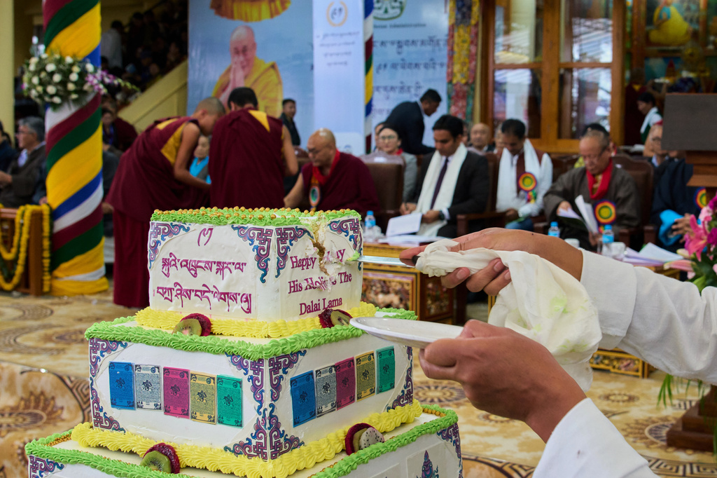 An exiled Tibetan cuts a large cake during the birthday celebrations of Tibetan spiritual leader the Dalai Lama at the Tsuglakhang temple in Dharamshala, India, Monday, July 6, 2026. (AP Photo/Ashwini Bhatia)