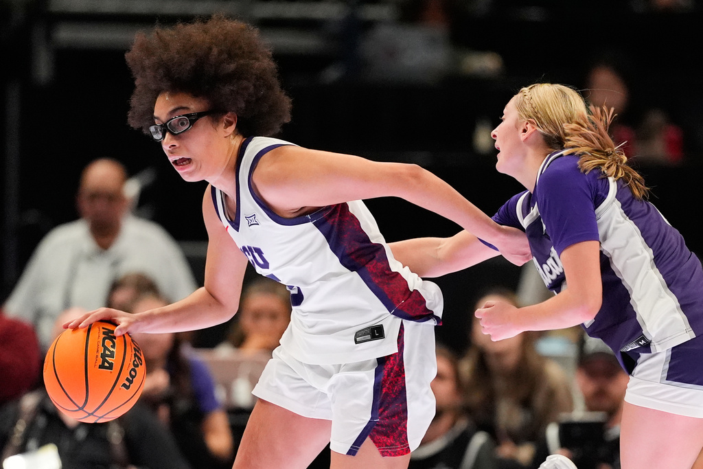 TCU's Olivia Miles, left, drives past Kansas State's Taryn Sides, right, during second half of an NCAA college basketball game in the semifinals of the Big 12 Conference tournament Saturday, March 7, 2026, in Kansas City, Mo. (AP Photo/Charlie Riedel)