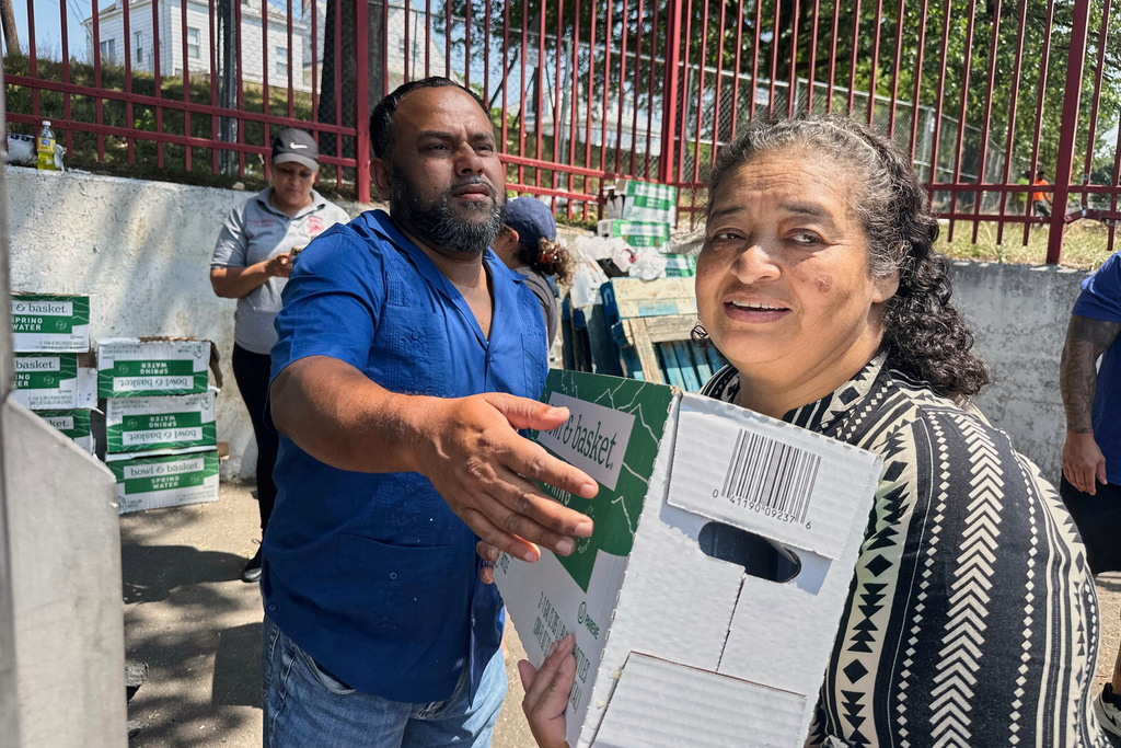 People, who were affected by a water main break that that led to reduced service to nearly 200,000 homes and businesses, pick up cases of bottled water at John F. Kennedy High School in Paterson, N.J., on Aug. 11, 2025. (AP Photo/Ted Shaffrey)
